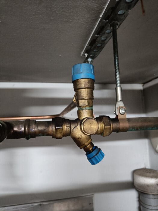 Vattenrör med blå ventilhattar; en stor ventil vrids för att släppa ut vatten.