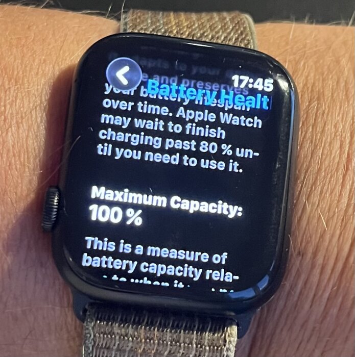 Smartklocka på handvisande batterihälsa med maximal kapacitet på 100%.