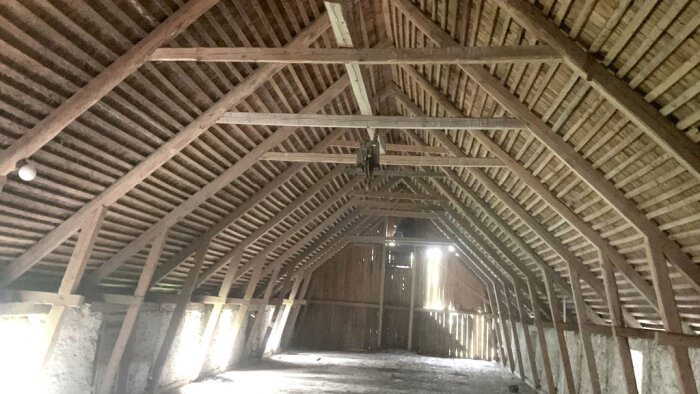 En traditionell svensk takstol på en vind, med trästödben och bjälklag, diskuterar takstolens konstruktion och stödbenens längd.