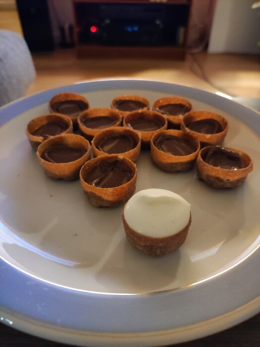 Croustader med smält dumlekola och en toppad med vispgrädde, serverade på en tallrik.
