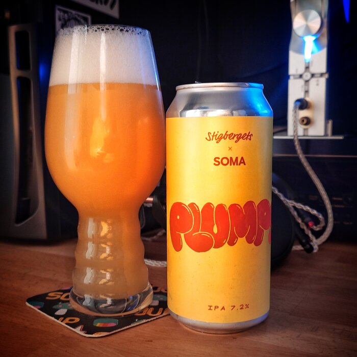 En halvfullt glas skummande öl bredvid en gul ölburk med texten Stigbergets x Soma Plump IPA 7.2%.