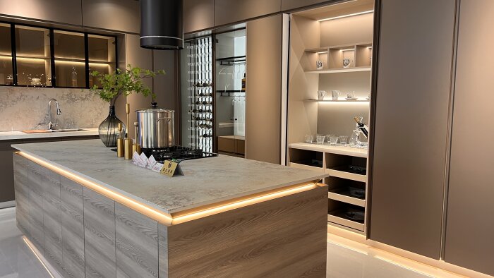 Modernt köksshowroom i Kina med köksö, inbyggda hyllor, marmorskivor, kran och dekorativa element.