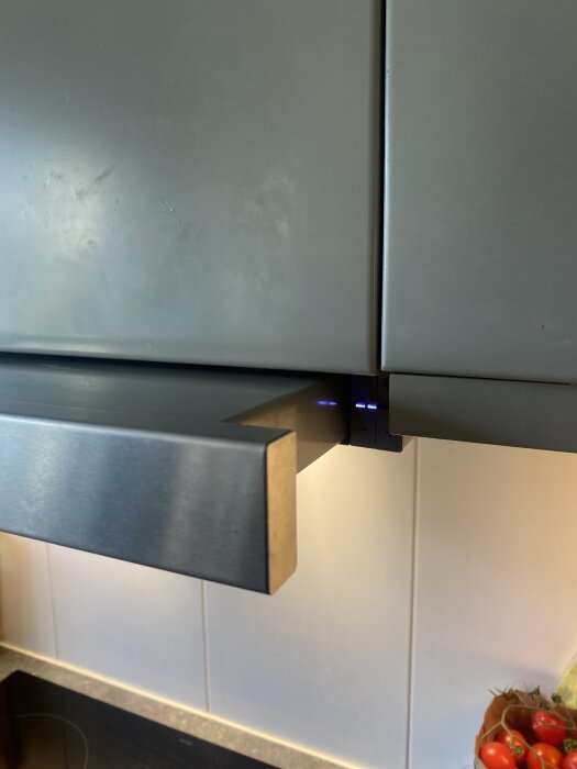 Siemens spisfläkt i grått med blå LED-lampor tända och köksinredning synlig i bakgrunden.
