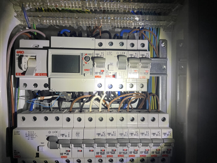 En elcentral med flera brytare, ledningar och ett digitalt displayfönster synliga.
