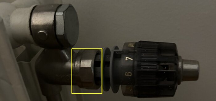 Muttrar och ventiler i närbild, monterade på ett rör, vilket antyder ett VVS-relaterat byggprojekt eller reparation.