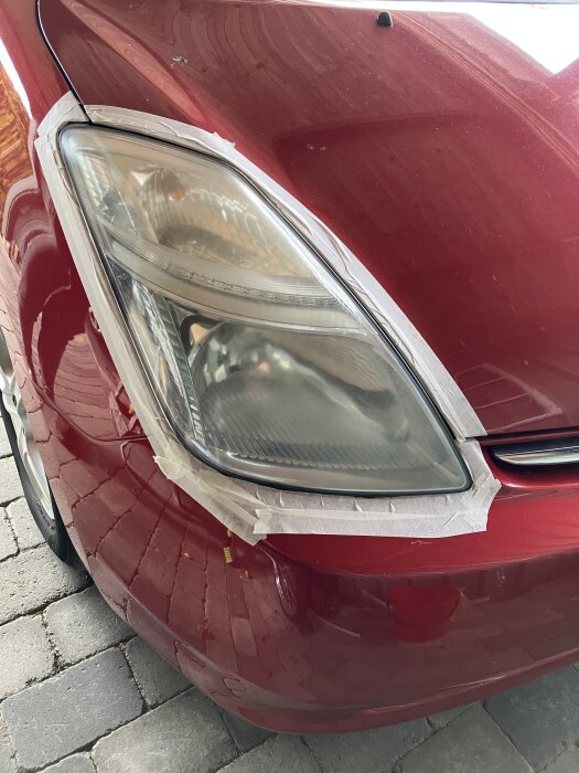Toyota Prius -07 strålkastare, maskerad med tejp för polering och våtslipning.