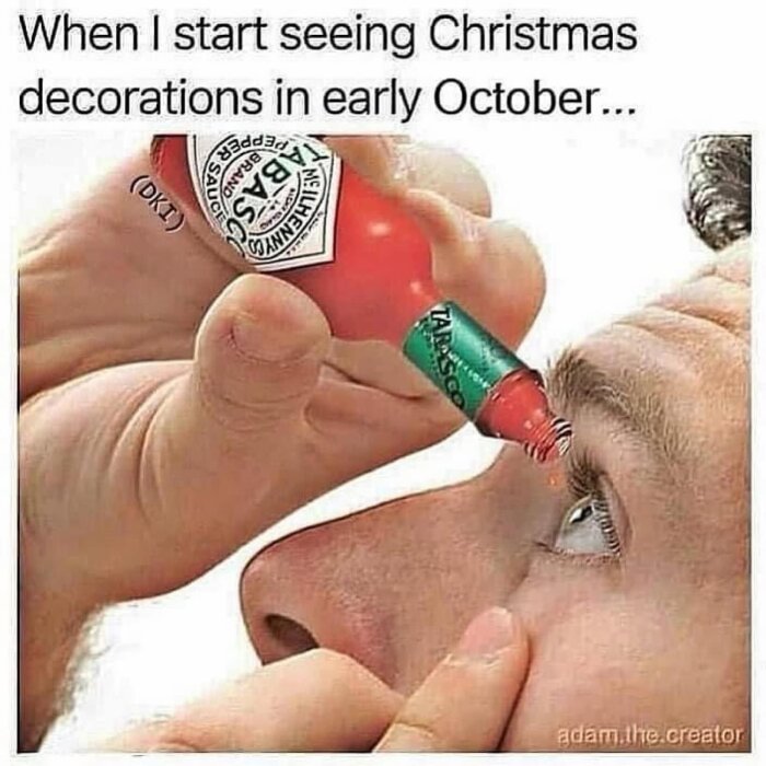 En person håller en flaska tabasco nära sitt öga, med texten "When I start seeing Christmas decorations in early October...