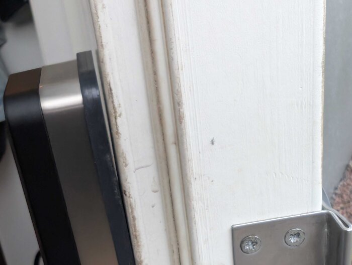 Monteringsplatta för dörrhandtag med glipande överkant mot dörr, visar ojämnt tryck vid installation av LS3-låset.