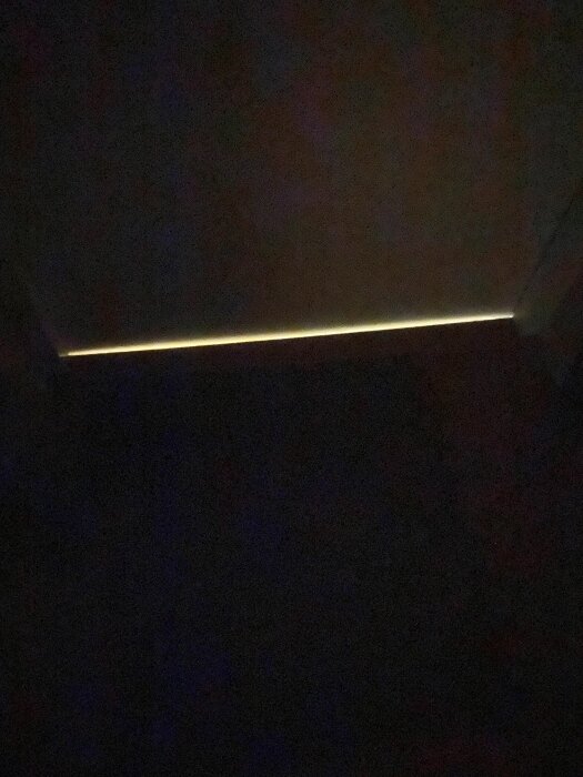 Glipa under ytterdörr där ljus sipprar in, potentiellt felaktig installation, ifrågasatt brandsäkerhet.