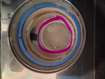 Avloppsbrunn i närbild med borttagen kopp och synlig blå gummiring, visar ett rör med inre struktur markerad i rosa.