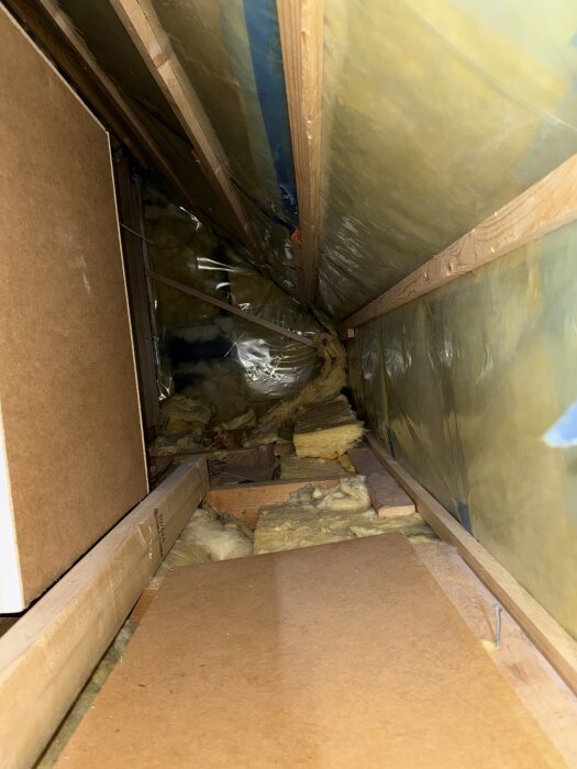 Isolering i kattvind med mineralull och plastfilm synlig; problemet med kemisk doft diskuteras.