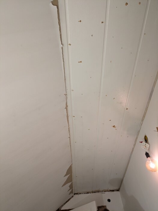 Tak med borttagna takplattor, visar ojämna kanter och befintliga spontbrädor, i samband med renovering av ett hus från 1929.