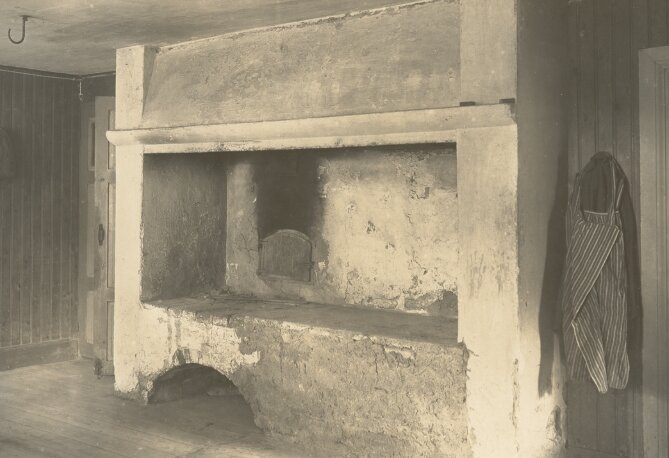 Gammal eldstad med smutsiga väggar och skorsten.