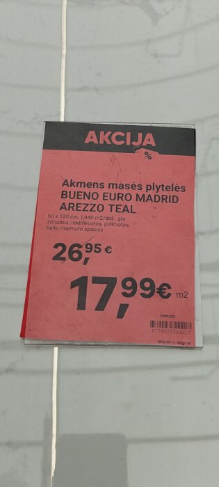 Reklamskylt med pris på klinkerplattor, "Akmens masės plytelės", ursprungligt pris 26,95 €, rabatterat till 17,99 € per m².