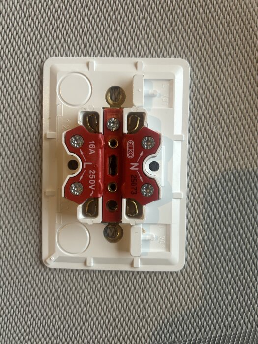 Eluttag med märkning "ELKO", visar 16A, 250V, med skruvar för kabelanslutningar.
