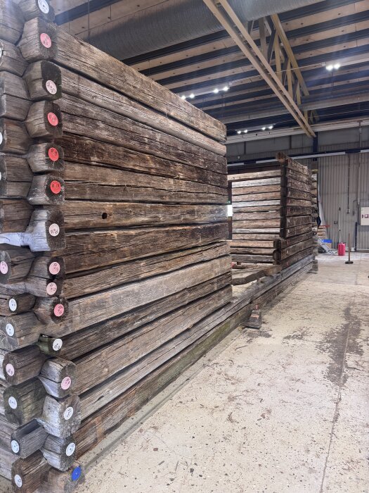 Timrad lada från 1800-talet, uppmärkt och nedplockad, i lagerlokal. Timmerstockarna har runda, numrerade markeringar.