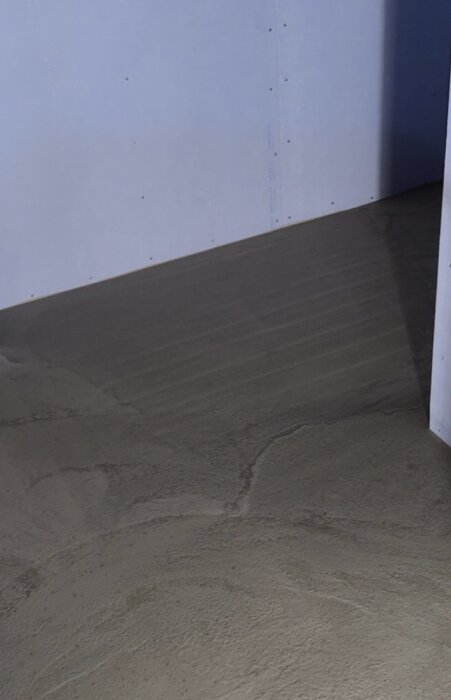 Flytspacklat badrumsgolv med synliga värmekablar nära duschen och golvbrunnen.