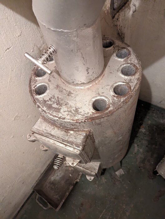 Rostig bastukamin med flera rör på toppen, ansluten till skorsten.