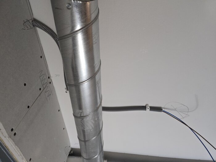 Flexrör och ventilationsrör på plats i taket, redo för eldragning och installation av takspottar i ett rum under renovering.