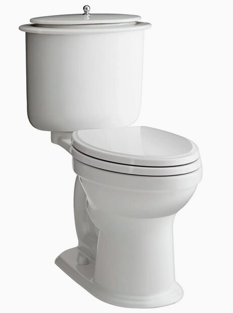 En vit toalett med ett handtag ovanpå cisternen, typiskt för 1980-talet, likt amerikanska modeller.