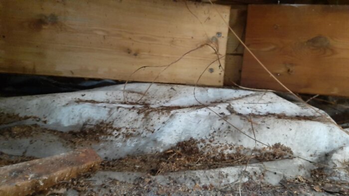 Bilden visar en träkonstruktion med reglar och bärlinor, samt marken med XPS-cellplastskivor, använd för att stödja ett spabad på en altan.