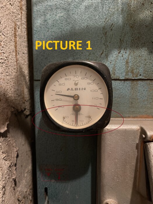 Manometer på Albin Special Nr. 1 träbrännare med två nålar, en svart och en röd, för visning av trycknivåer.