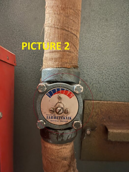 Närbild av en Värmeteknik shuntventil med en skala från 0 till 10, installerad på en isolerad rörledning.