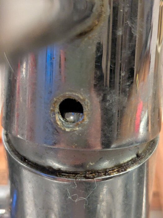 FM Matsson blandare med avlägsnat röd-blå lock, visar insidan av metallröret med en öppning där inget är synligt för att skruva.