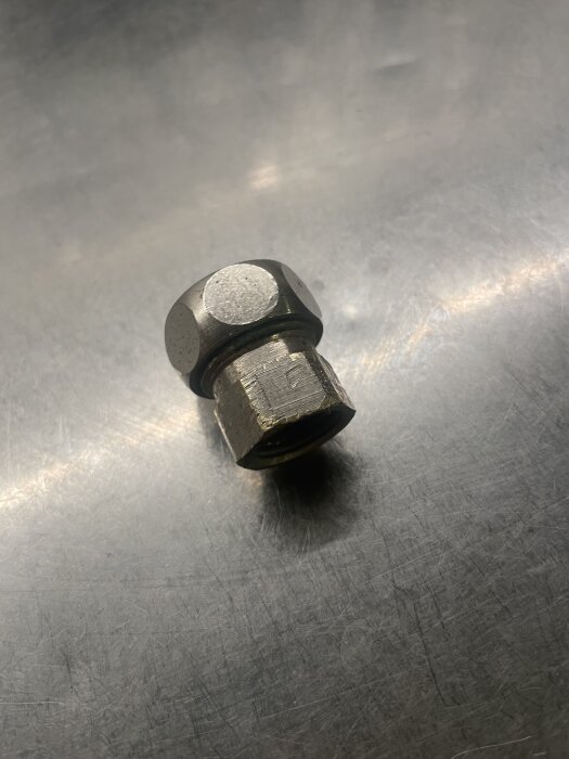 Metallisk rörkoppling på en yta, används för anslutning i ett VVS-system, diskuteras i samband med blandaranslutning och bussning.