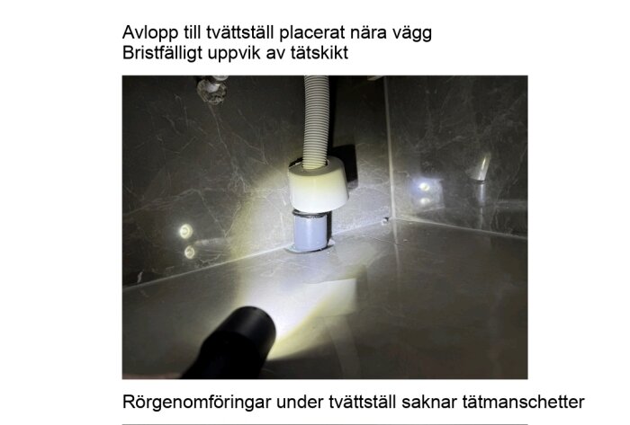 Avloppsrör under tvättställ nära vägg, med bristfälligt uppvik av tätskikt och saknad tätmanschett, upplyst av ficklampa mot kaklad väggyta.