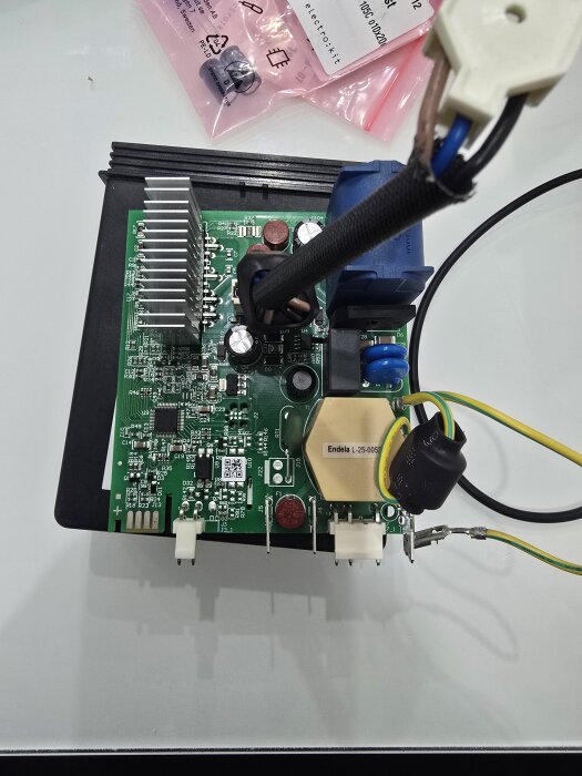 Grönt styrkort för kompressor visas med elektroniska komponenter, kablar och kylfläns.