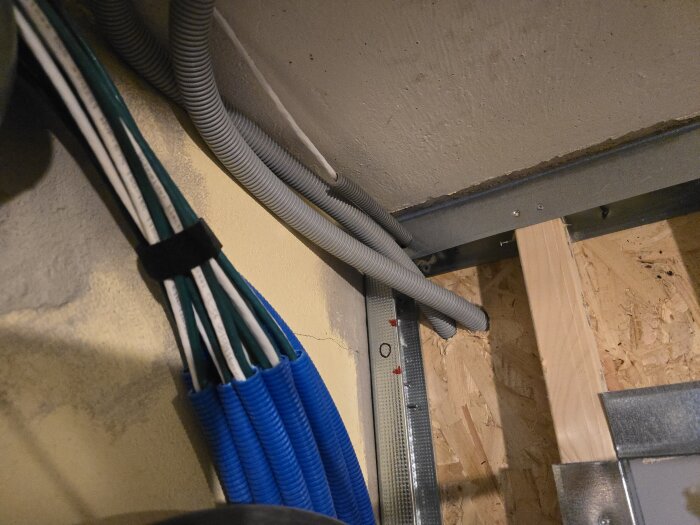 Flexrör och elektriska kablar installerade i ett tak med träbas och osb-skivor.