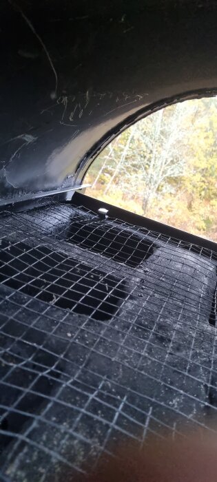 Nät av metall med fyra flikar i en skorsten. Fråga om hur flikarna ska fästas.