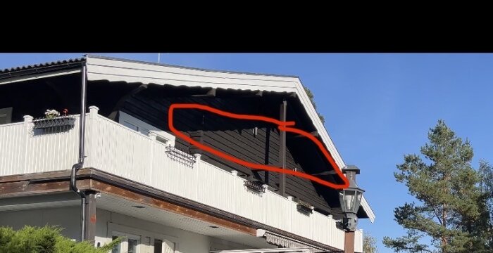 Takfot av hus inifrån vinden, med svart träbeklädnad och en rödmarkerad sektion på bilden.
