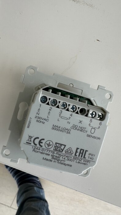 En vit elkomponent med skruvanslutningar märkta 1-6, för 230VAC, maxlast 3000W/13A. Märkt "Raychem SENZ WIFI". Ligga på en ljus yta.