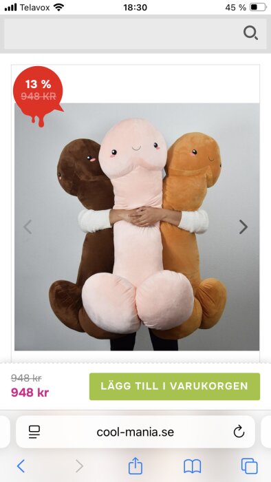 Tre stora kuddar formade som leksaker, föreställande olika färger, hålls av en person mot en vit bakgrund.