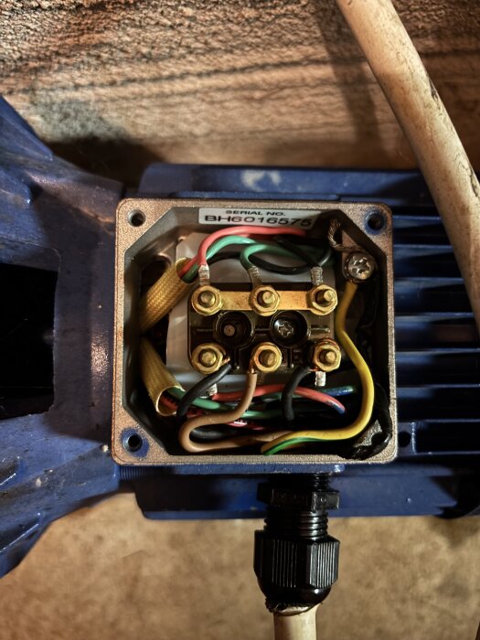 Blå jetpump med synliga kopplingskablar och seriell etikett, visar detaljerad elinstallation för renoveringsprojekt.