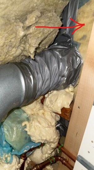 Mineralull och fogskum på yttervägg med ett plaströr och tejp synliga; frågetecken om plast barriär finns framför mineralullen.