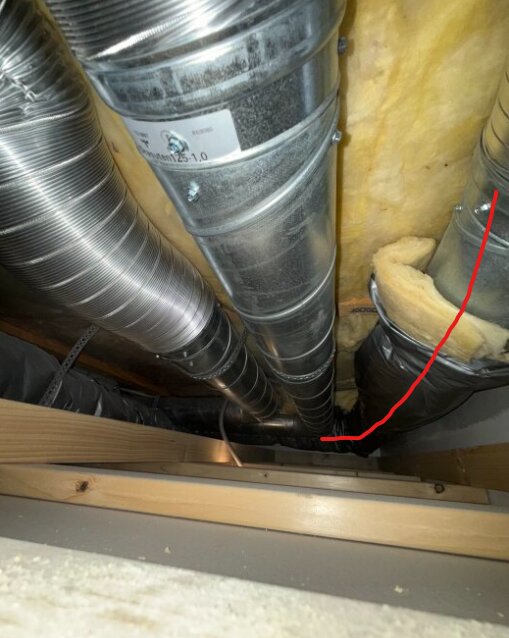 Ventilationsrör i ett trångt utrymme; ett rör är markerat med röd linje och omgiven av isolering.