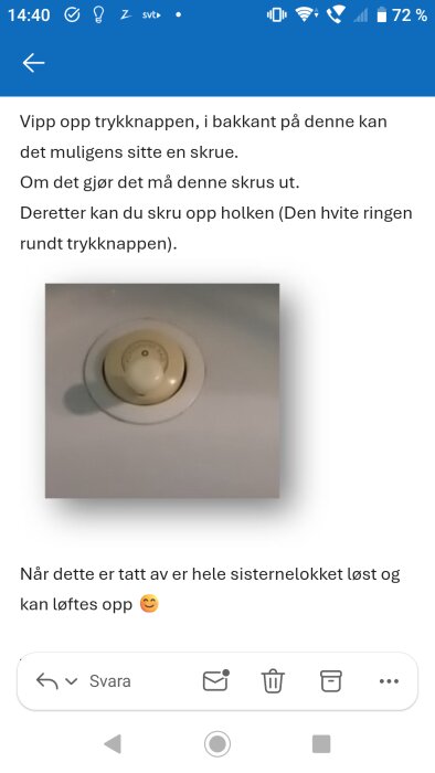 Toalettknapp på Porsgrund-toalett med instruktioner för hur man avlägsnar locket på cisternen. Vit ring runt en central knapp.