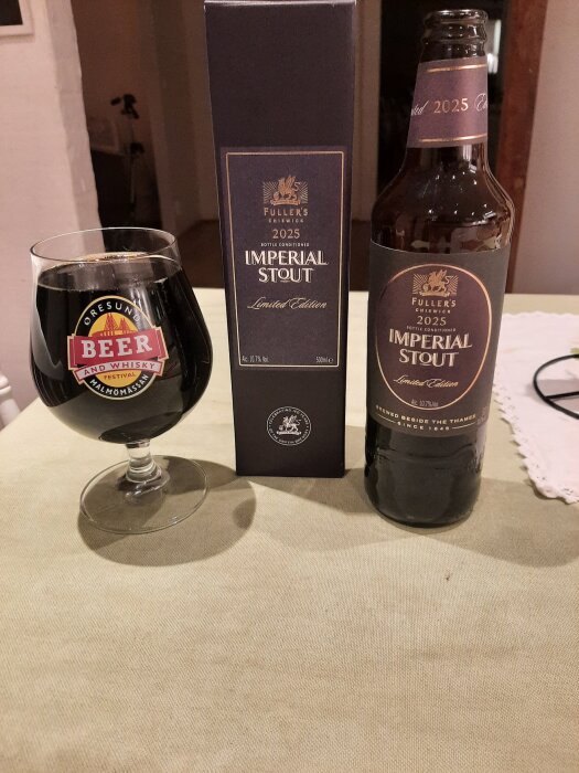 Flaska och glas med Fuller's 2025 Imperial Stout Limited Edition på ett bord, bredvid kartongen.