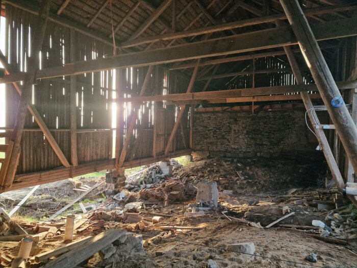 Renovering på loge med exponerade träbjälkar, jordig mark och byggmaterial. Solstrålar genom springorna i väggpanelen.