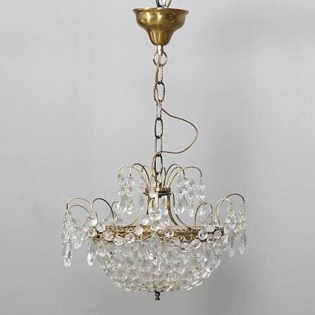 Gammal kristallkrona med guldfärgad stomme och hängande kristaller, avsedd som inspiration för badrumsinstallation.