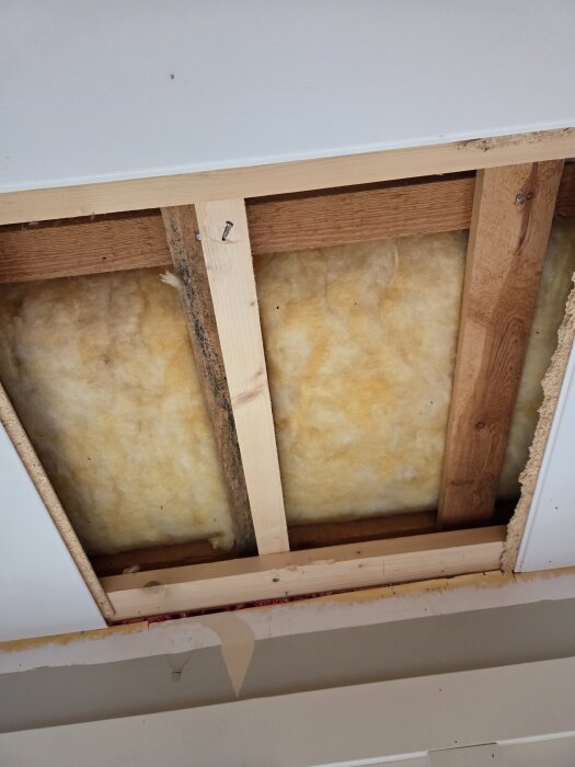 Öppen hålighet i taket med regelverk synligt, isolering mellan reglarna och intilliggande takmaterial.