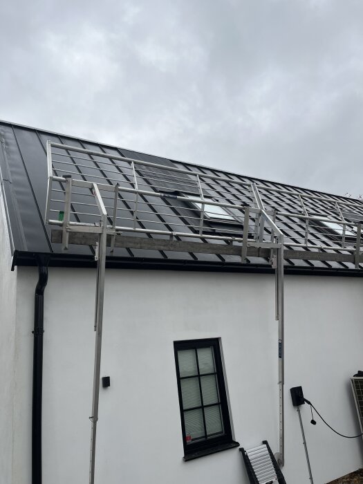 Tak av plåt med fyra takfönster installerade, säkerhetsställning monterad.