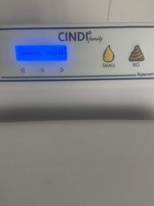 Display på Cindi-toalett med meddelandet "VÄRMEFEL OMSTART" lysande i blått.