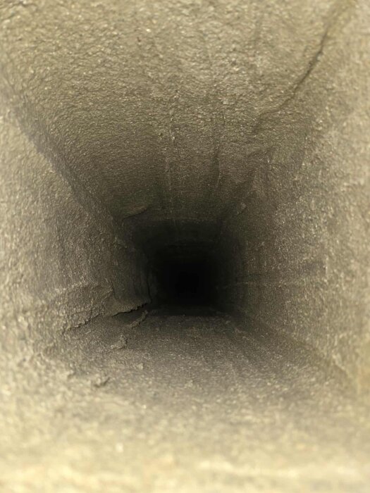 Vy inuti en kvadratisk skorsten med grov yta, del av glidgjutningsprojekt.