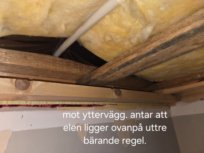 Isolerat innertak med träreglar och kabeldragning. Rör synligt ovanpå regel vid yttervägg; text indikerar möjlig flytt av el.