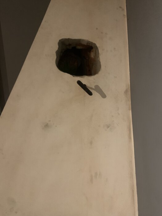 Öppning i eldstadsvägg för kassettinstallation, synlig urtag för anslutningsrör.