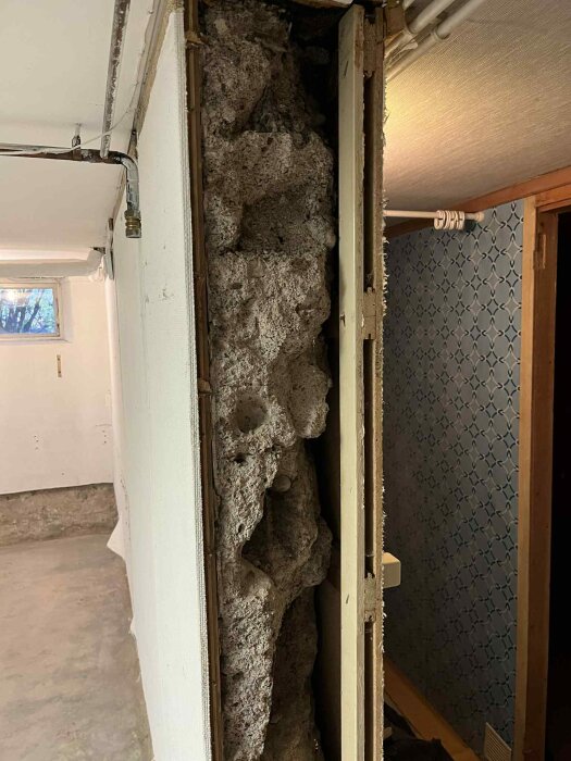 Oregelbunden och ojämn bärande vägg i en 1934 källare, med stora håligheter och lösa delar, avtäckt under renovering.